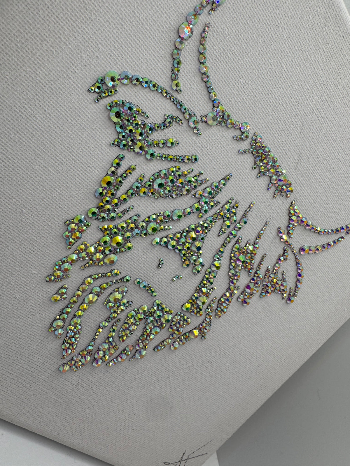 Decorative piece with rhinestone embellishments on a white canvas background