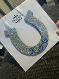 Decorative item with a horseshoe design made of rhinestones on a white background.