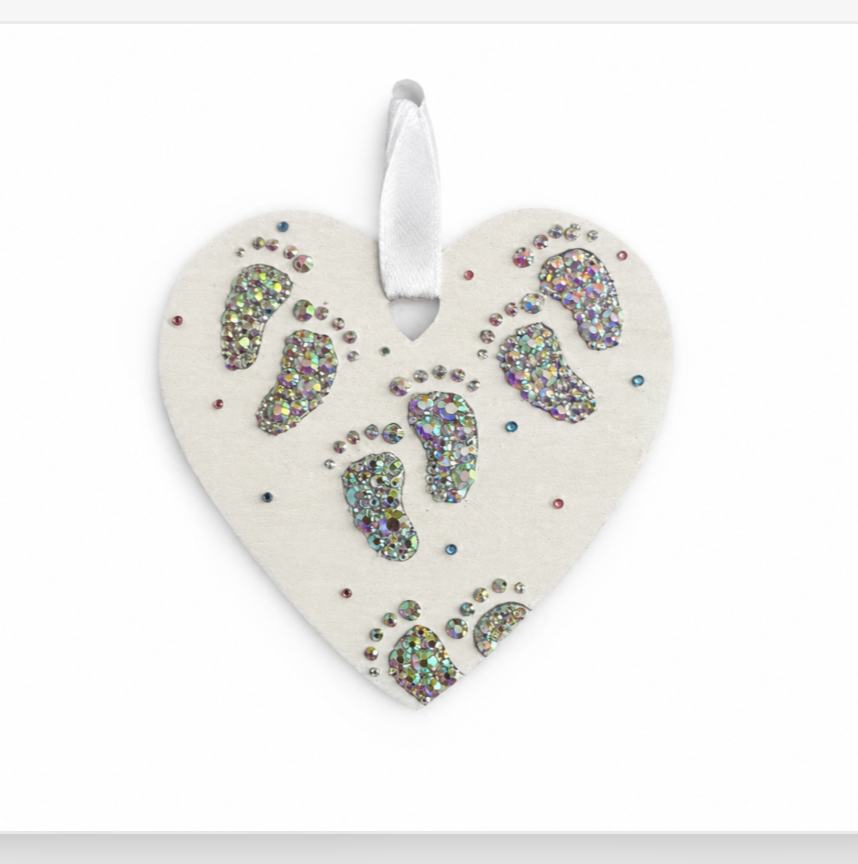 Heart-shaped decorative item with footprints on a white background